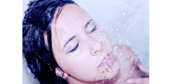 Lady holding her face under the shower stream