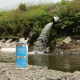 Wastewater treatment canal, h2olabcheck plastic sampling bottle stands in front of it